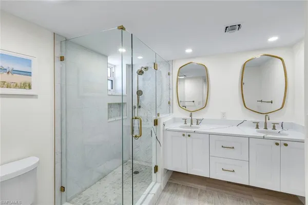 a bathroom with a double vanity sink mirror and toilet