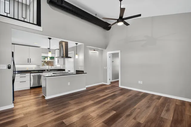 a kitchen with stainless steel appliances granite countertop a sink cabinets and wooden floor