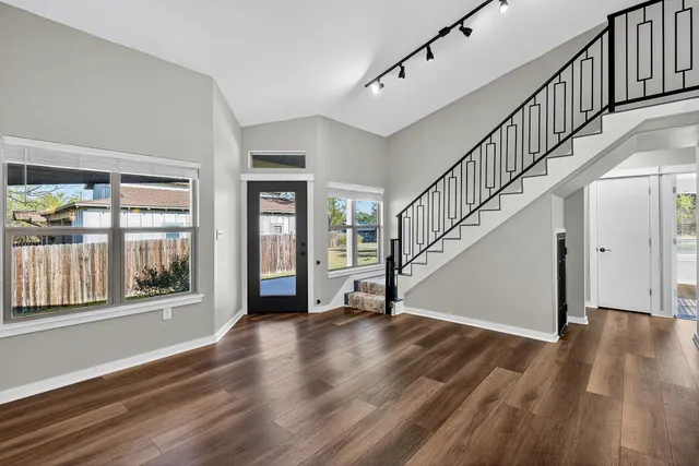 a view of an entryway with wooden floor door and windows