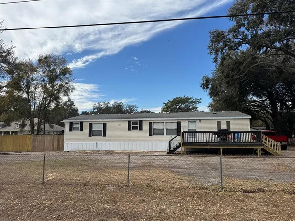 a view of a house with a backyard and a tree
