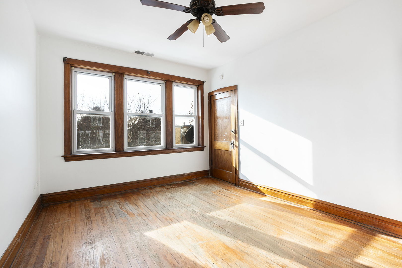 3128 West 41st Street Chicago, IL 60632 - Photo 9 of 36 a view of an empty room with a window and wooden floor