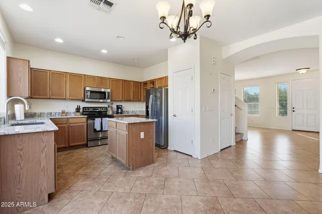 a bedroom with a large bed and a chandelier