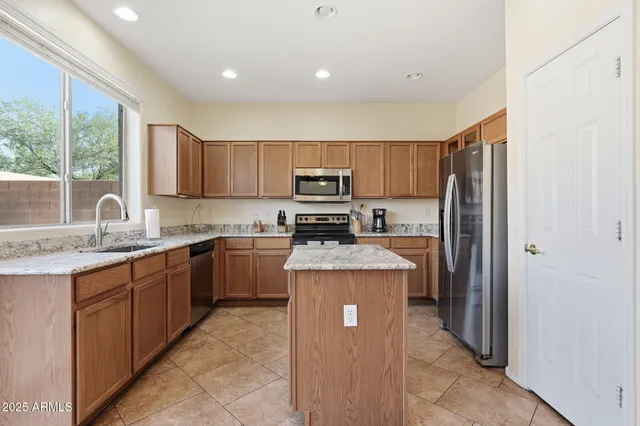an empty room with a chandelier fan and windows