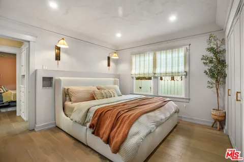a bedroom with a bed closet and a large window