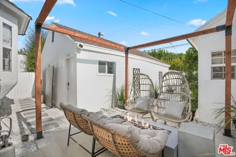 a view of patio with couches table and chairs and potted plants