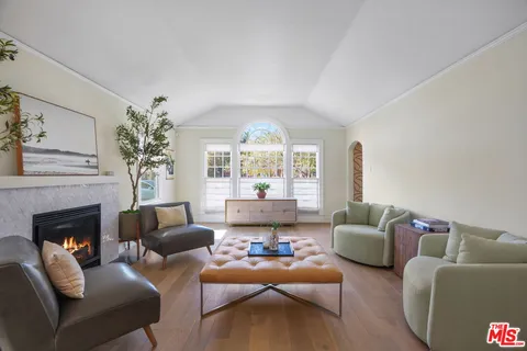 a living room with furniture fireplace and a large window