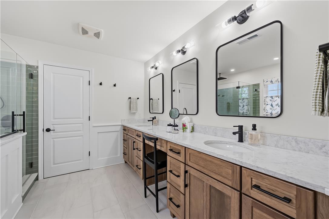 9031 Pathfinder Road Breinigsville, PA 18031 - Photo 35 of 63 Clean lines define this bright primary bathroom, boasting a spacious double vanity with ample storage and a walk-in shower.
