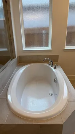 a bathroom with a tub sink and a mirror