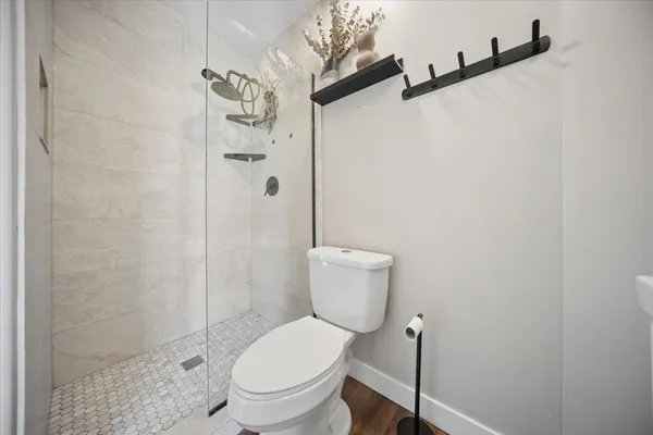 a white toilet sitting next to a shower