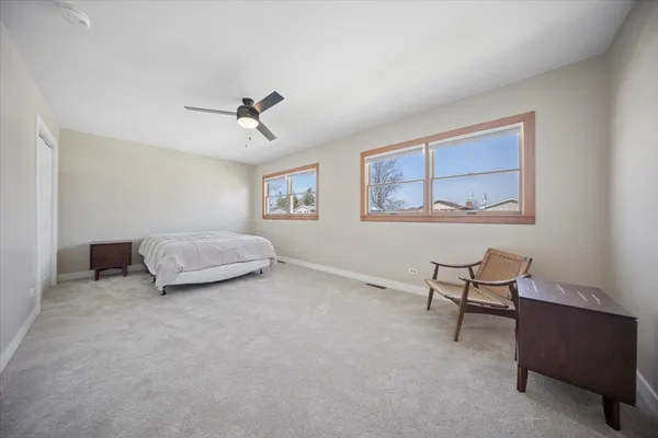 a spacious bedroom with a bed a table and chair