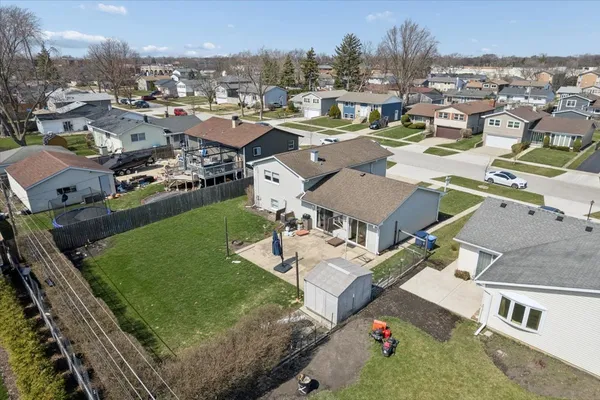 an aerial view of residential houses with outdoor space and parking