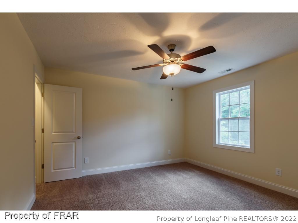 210 Dicks Hill Road Carthage, NC 28327 - Photo 19 of 29 a view of an empty room with a ceiling fan and window