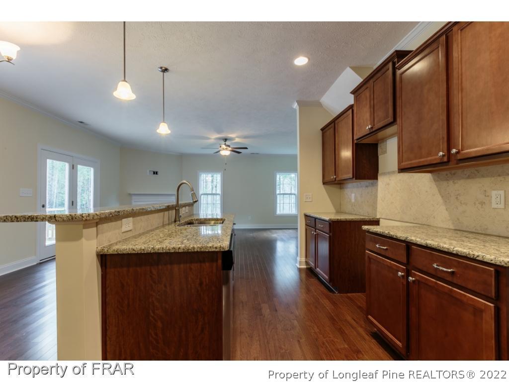 210 Dicks Hill Road Carthage, NC 28327 - Photo 8 of 29 a kitchen with granite countertop kitchen island stainless steel appliances a sink cabinets and wooden floor