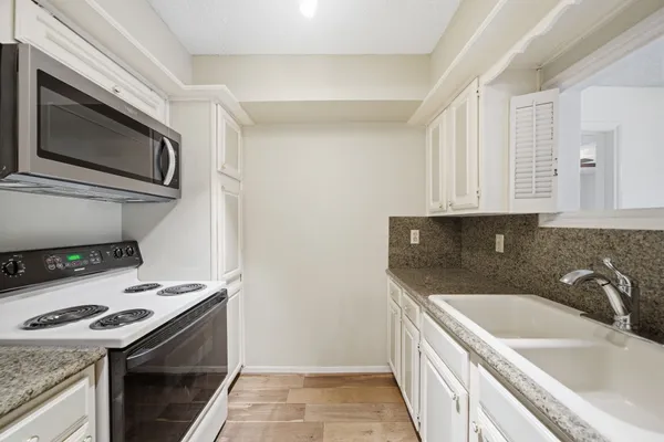 a kitchen with a sink stove and cabinets