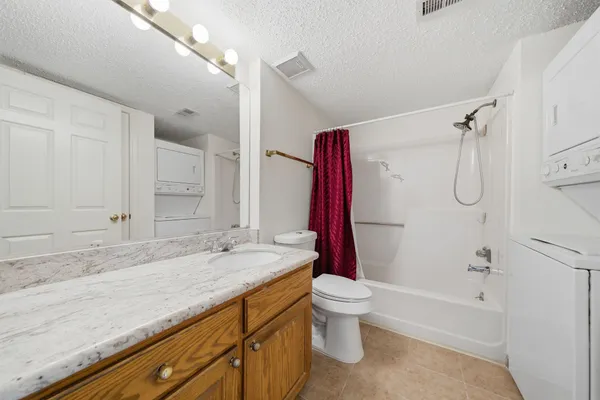 a bathroom with a granite countertop sink a toilet and shower