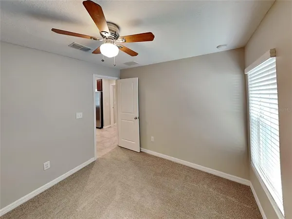 an empty room with closet and a ceiling fan