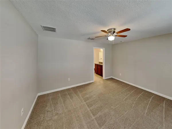a view of an empty room with a ceiling fan