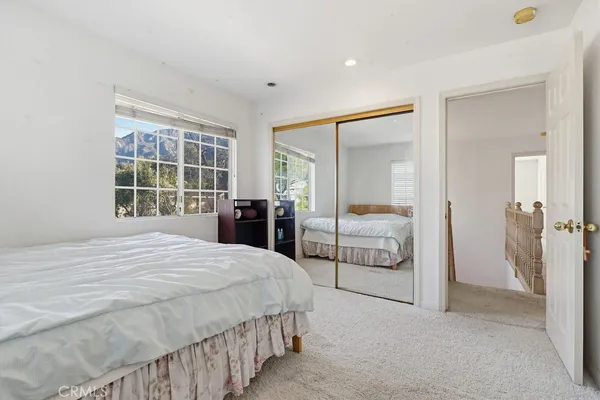 a bedroom with a bed dresser and a fireplace