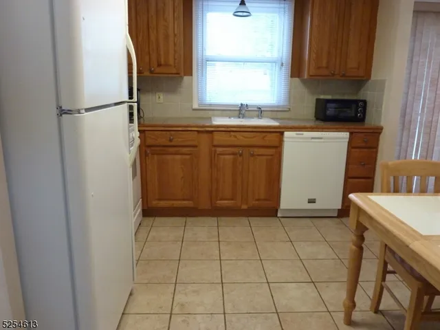 a kitchen with a sink a refrigerator and cabinets