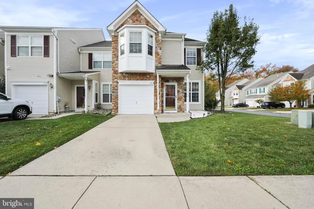 a view of a white house with a yard and plants