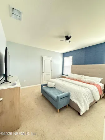 a spacious bedroom with a bed and a flat screen tv