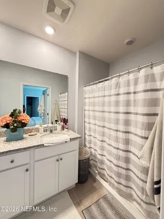 a en suite bathroom with a double vanity sink a mirror and a shower