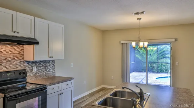 a kitchen that has a sink cabinets counter space and a window
