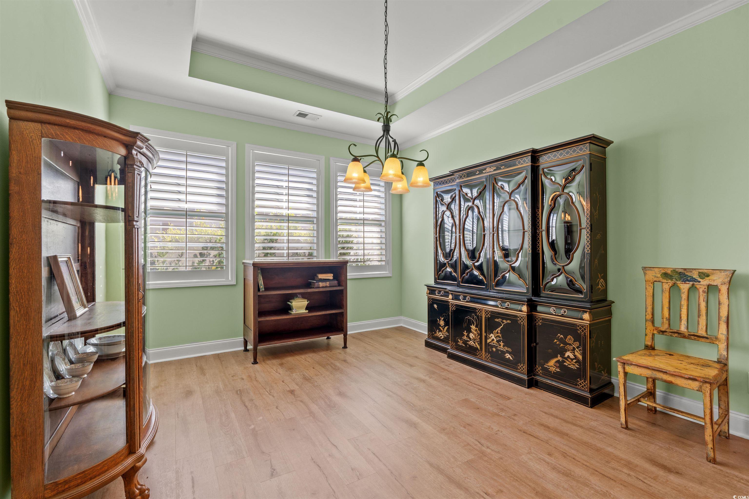 570 Botany Loop, Unit 570 Murrells Inlet, SC 29576 - Photo 16 of 36 Living area with visible vents, a chandelier, crown molding, wood finished floors, and a raised ceiling