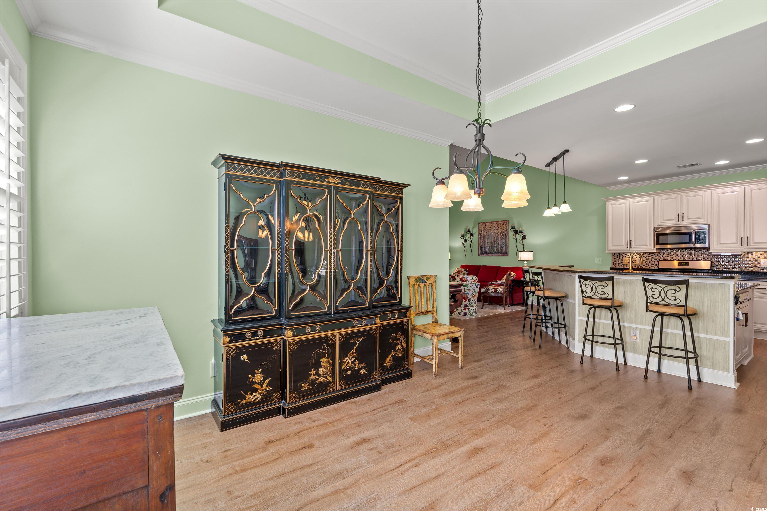570 Botany Loop, Unit 570 Murrells Inlet, SC 29576 - Photo 17 of 36 Dining area with a chandelier, crown molding, light wood finished floors, and recessed lighting