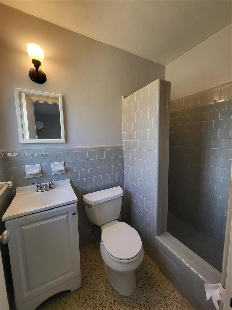 200 Southeast 3rd Street, Unit 2 Dania Beach, FL 33004 - Photo 4 of 5 a bathroom with a toilet a sink and mirror