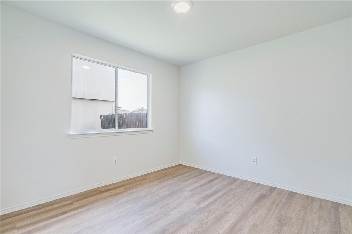 100 Easy Street Hutto, TX 78634 - Photo 20 of 36 A well-lit room offers fresh flooring and abundant natural light.