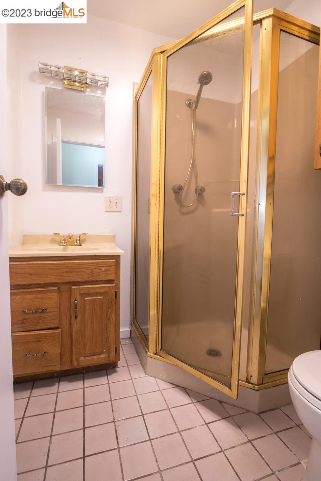 2205 Curtis Street Berkeley, CA 94702 - Photo 13 of 38 a bathroom with a shower a mirror and a sink