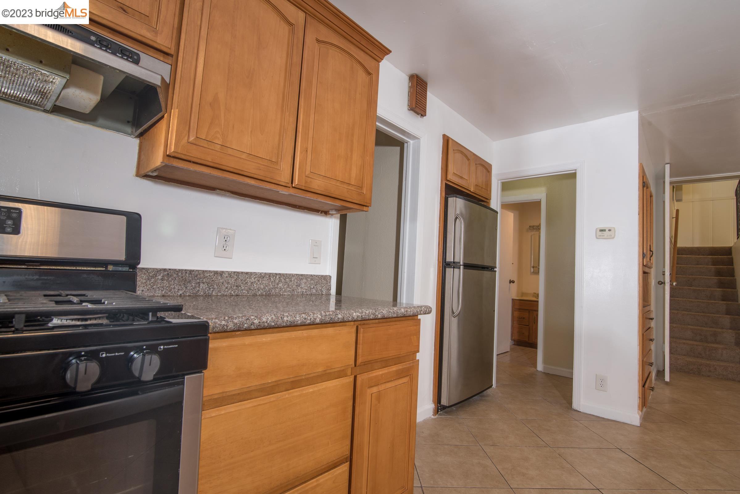2205 Curtis Street Berkeley, CA 94702 - Photo 28 of 38 a kitchen with stainless steel appliances granite countertop a refrigerator stove and cabinets