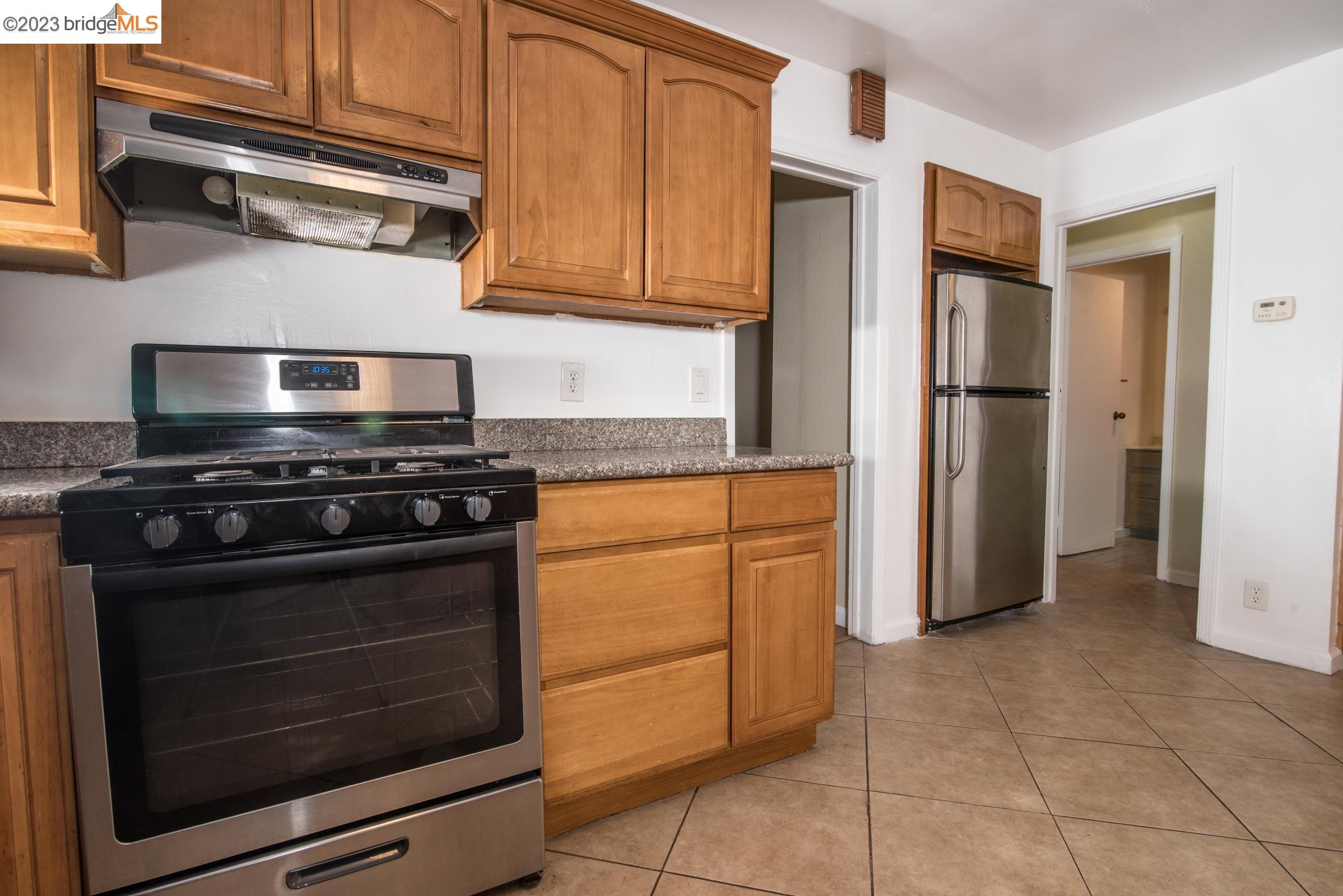 2205 Curtis Street Berkeley, CA 94702 - Photo 29 of 38 a kitchen with stainless steel appliances granite countertop a stove microwave and refrigerator