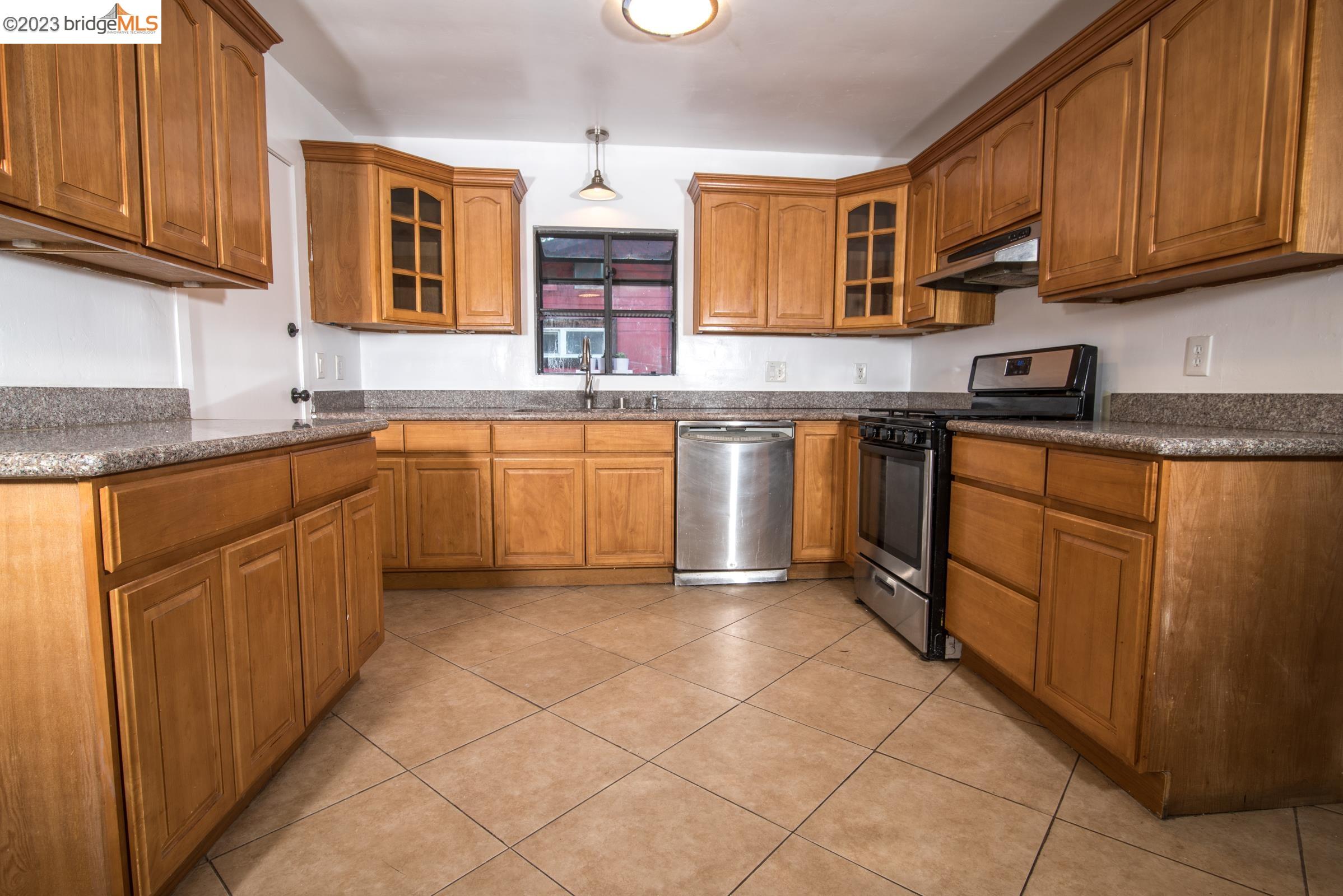 2205 Curtis Street Berkeley, CA 94702 - Photo 30 of 38 a kitchen with stainless steel appliances granite countertop a sink stove and cabinets