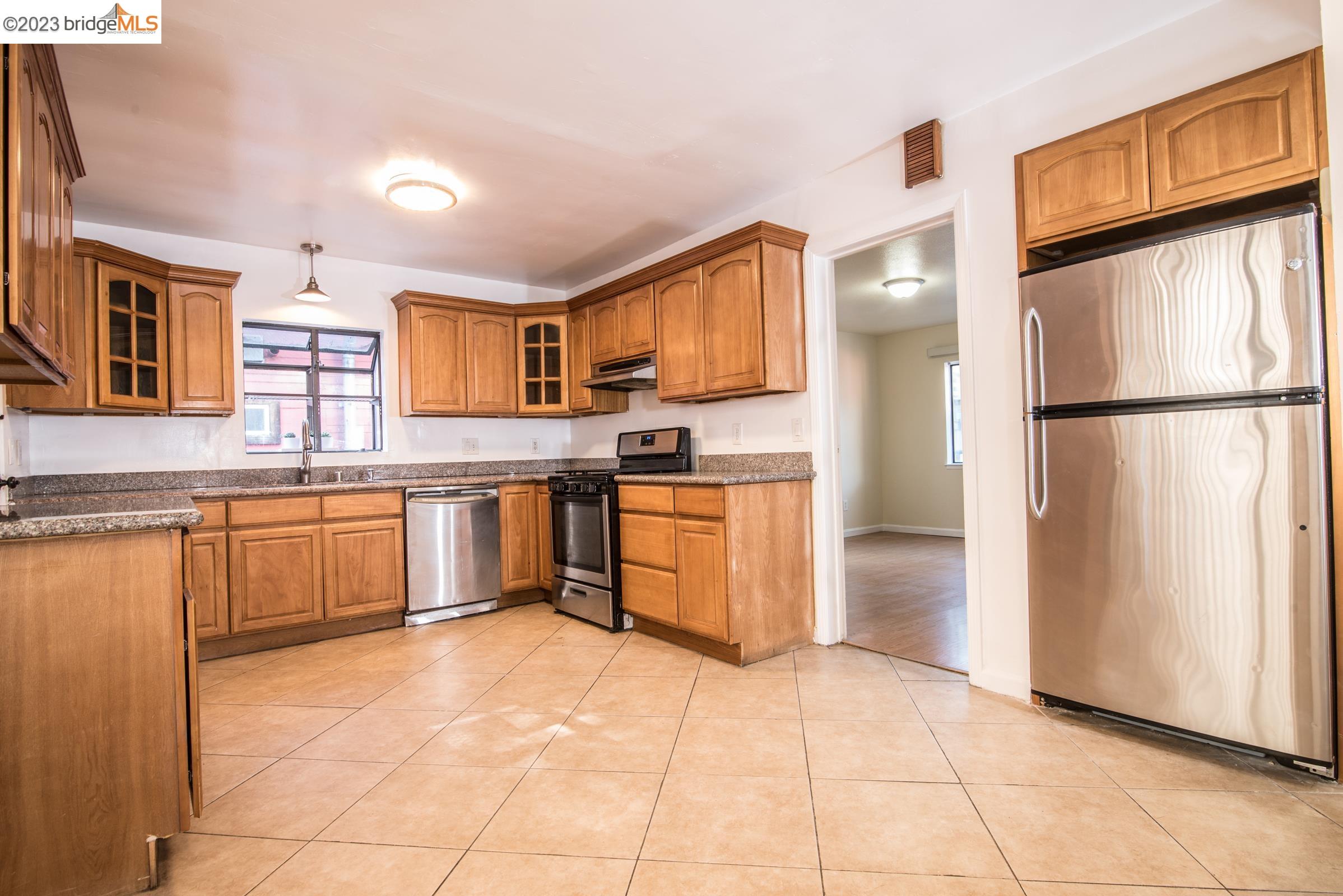 2205 Curtis Street Berkeley, CA 94702 - Photo 31 of 38 a kitchen with stainless steel appliances granite countertop a refrigerator sink and cabinets