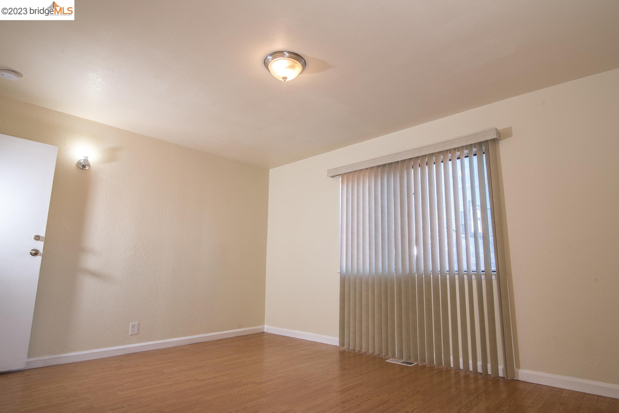 2205 Curtis Street Berkeley, CA 94702 - Photo 6 of 38 wooden floor in an empty room with a window