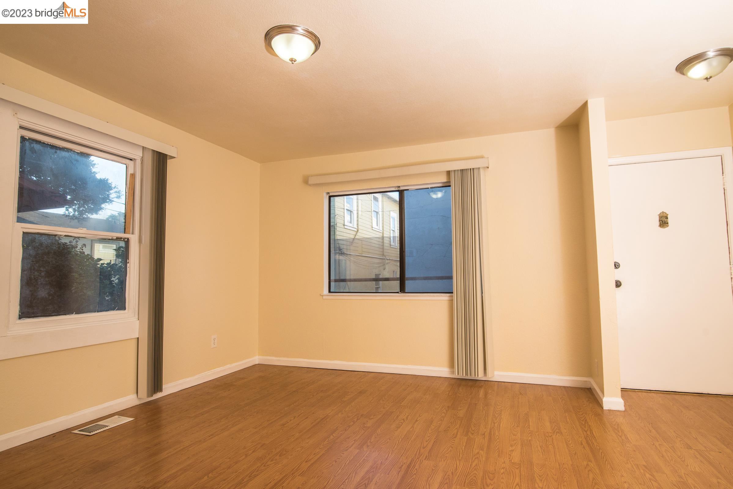 2205 Curtis Street Berkeley, CA 94702 - Photo 7 of 38 a view of an empty room with wooden floor and windows