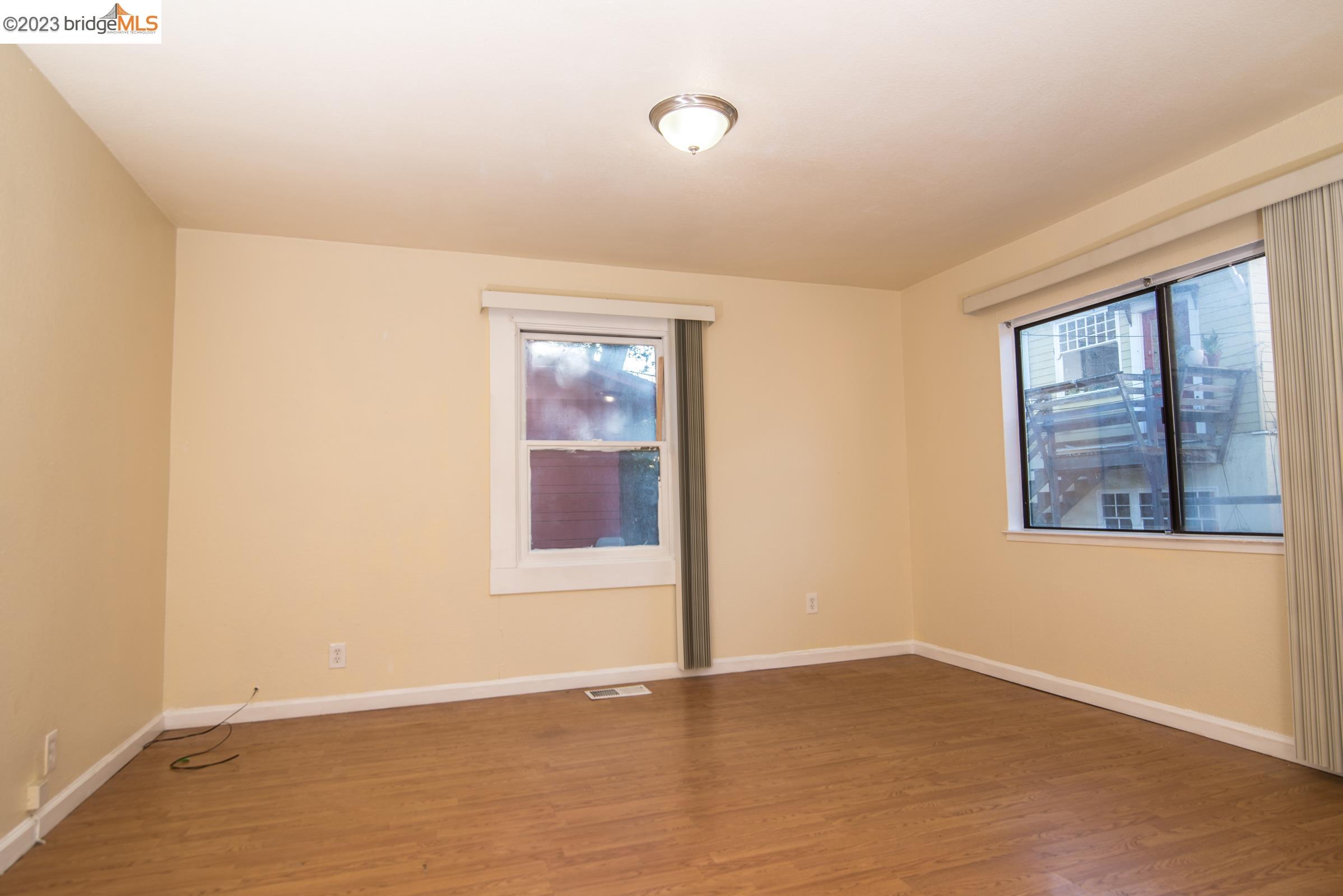2205 Curtis Street Berkeley, CA 94702 - Photo 8 of 38 an empty room with wooden floor and windows