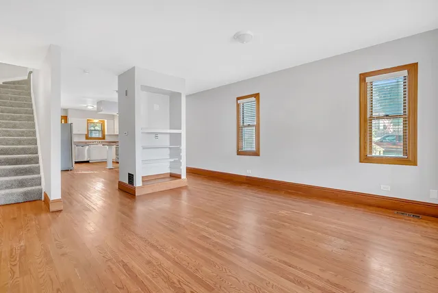 a view of empty room with wooden floor and window