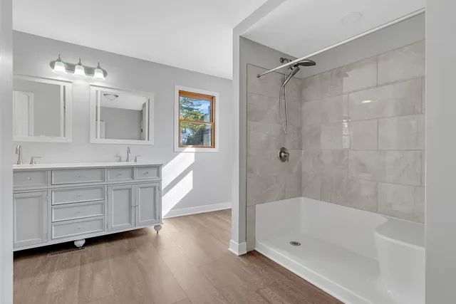 a bathroom with a tub sink and mirror