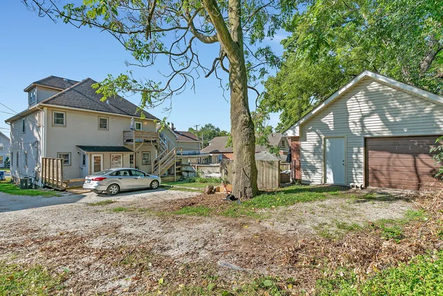 a view of a house with a yard and large trees