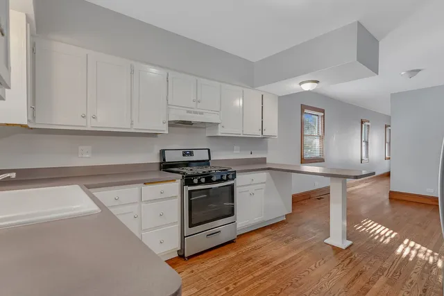 a kitchen with granite countertop wooden floors and stainless steel appliances
