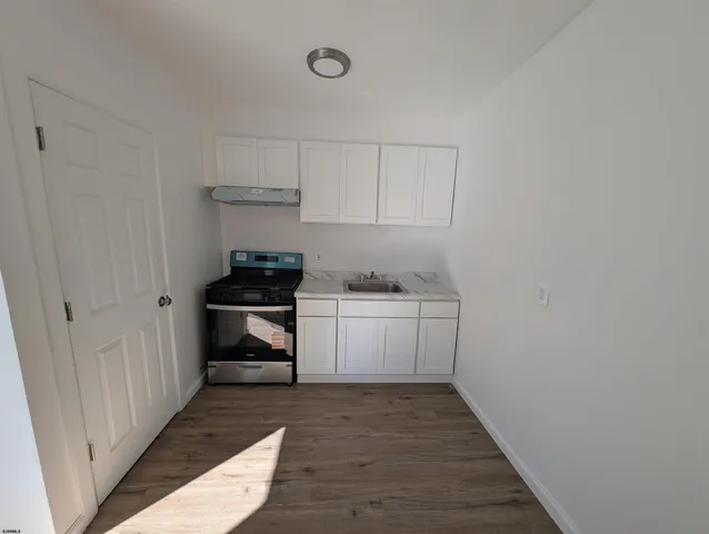 a kitchen with a cabinets and wooden floor