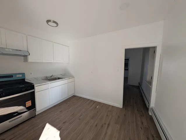 a kitchen with a wooden floor and cabinets