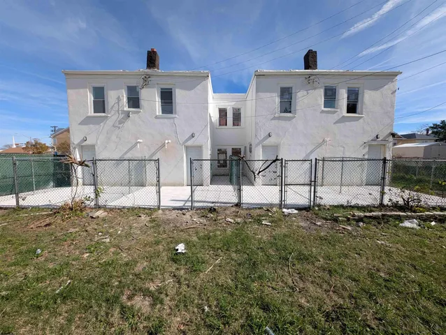 a white house that has a tree in front of it