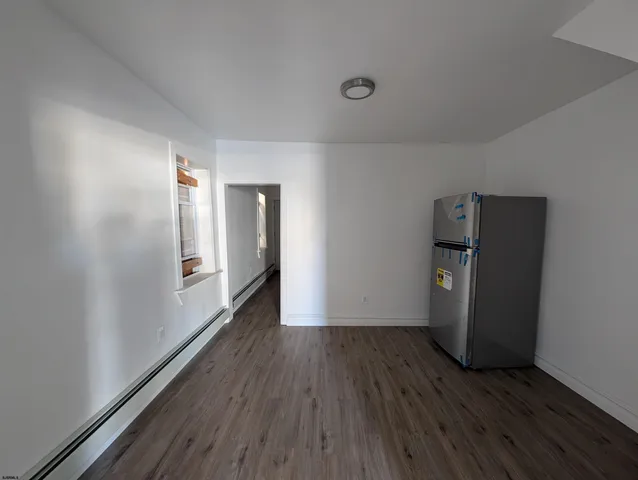 a view of a room with wooden floor and electronic appliances