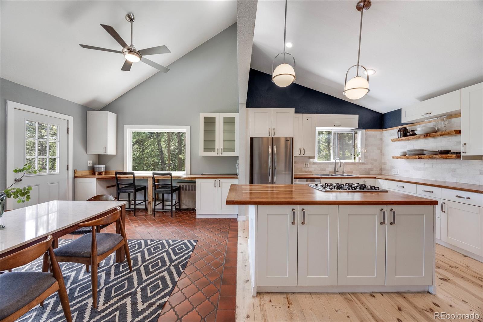 8783 Ault Lane Morrison, CO 80465 - Photo 11 of 40 a kitchen with stainless steel appliances granite countertop a sink a stove a dining table and chairs