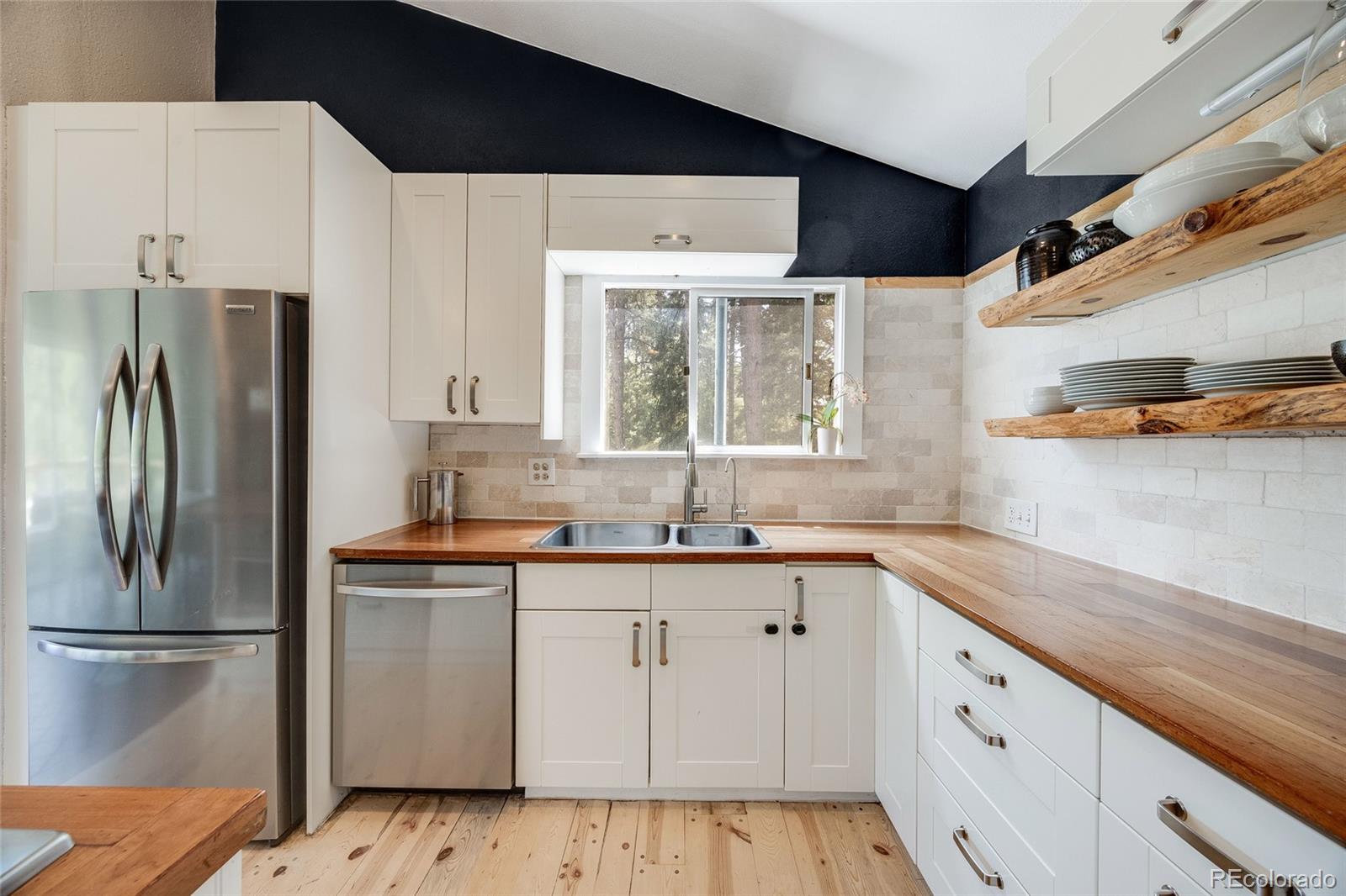 8783 Ault Lane Morrison, CO 80465 - Photo 14 of 40 a kitchen with a sink a refrigerator and cabinets