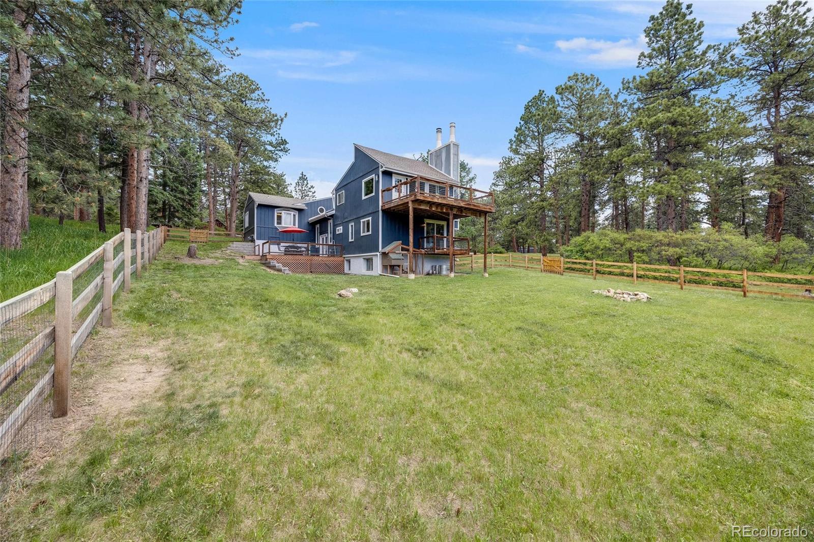 8783 Ault Lane Morrison, CO 80465 - Photo 39 of 40 a view of a house with pool and a yard